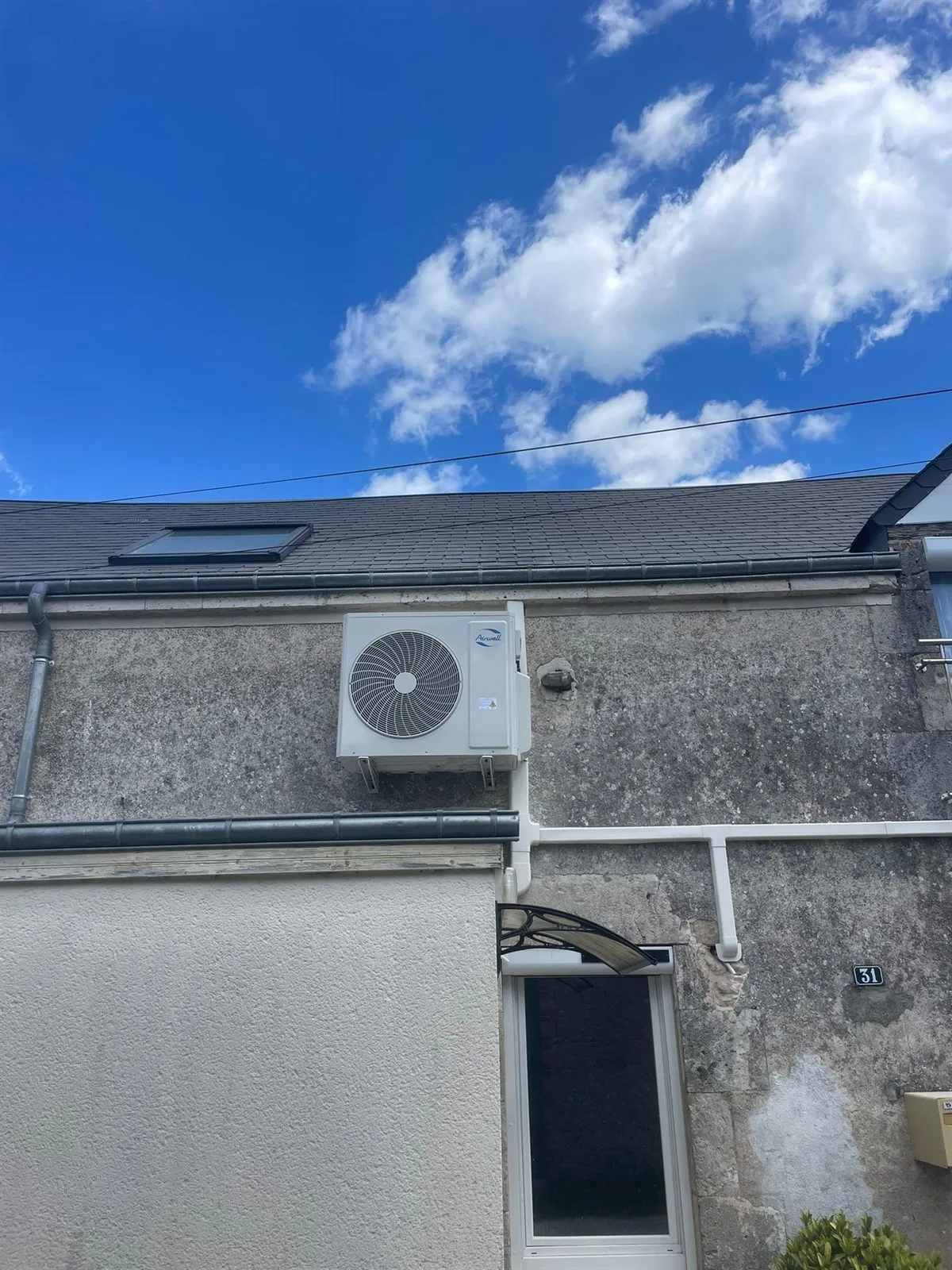 Unité extérieure de pompe à chaleur air-air fixée en applique sur une façade