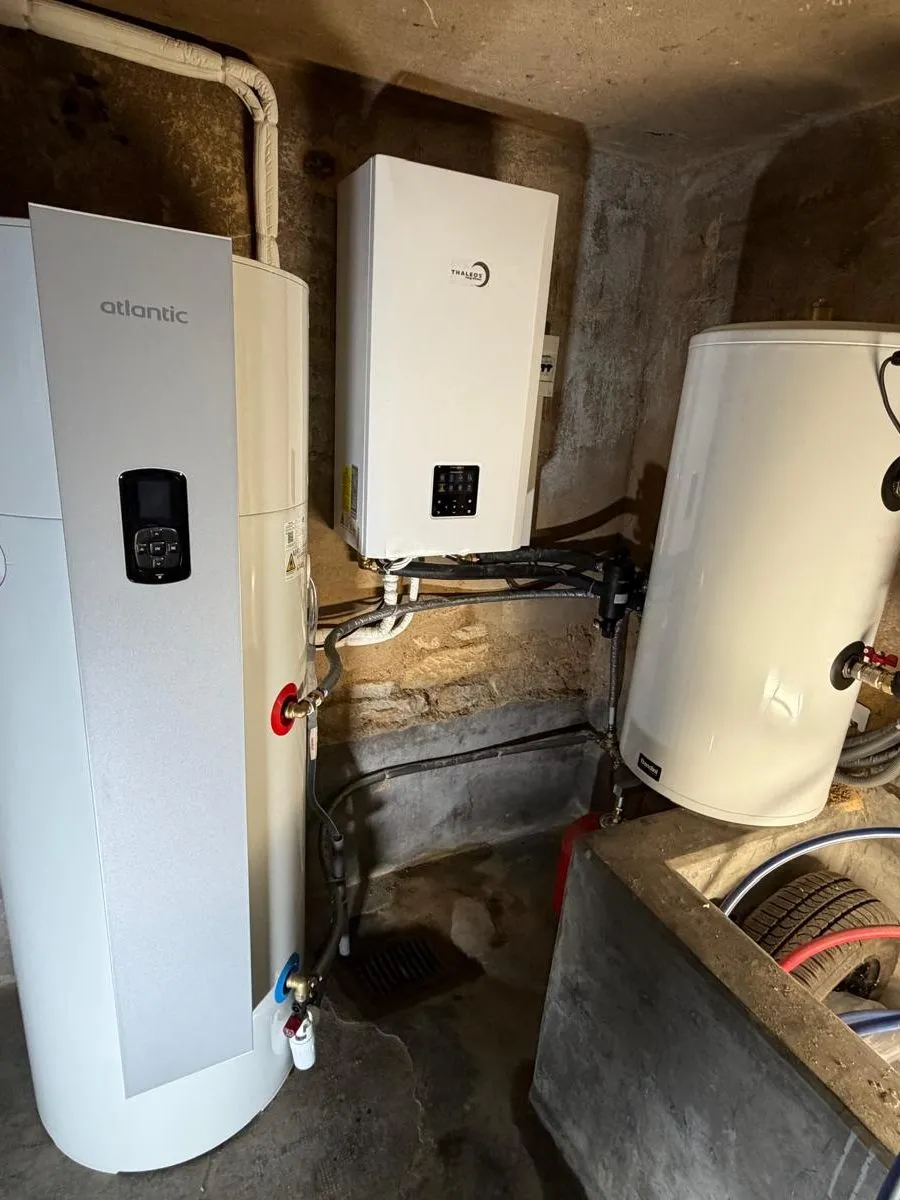 Deux modules muraux de pompe à chaleur et un ballon installés côte à côte dans un local